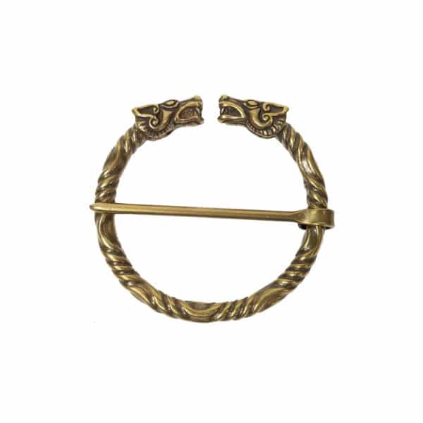 The Wolf Penannular Brooch is a circular bronze accessory featuring intricately designed dragon heads facing each other at the ends, with a pin running through the middle, evoking ancient wolf motifs.