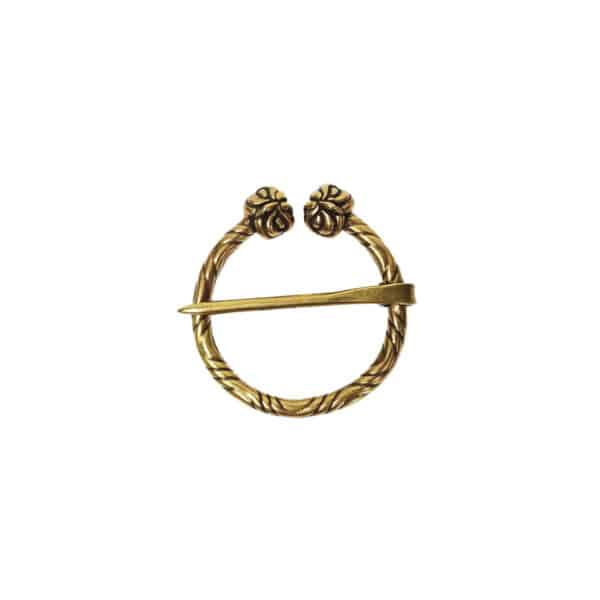 A circular gold brooch with a pin across the diameter, featuring intricate owl head designs at the ends, resembling an ancient penannular brooch called the Owl Penannular Brooch.