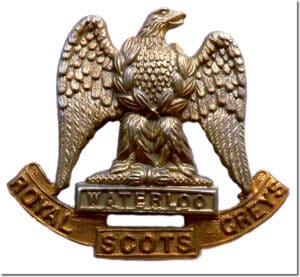 A gold eagle from the Scots Greys Cavalry with a white background.