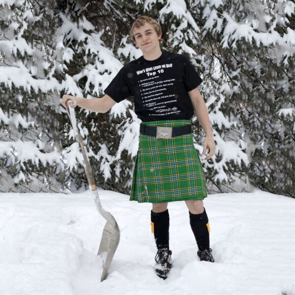 A young man wearing a Quality Wool Blend Kilt for Teens standing in the snow.