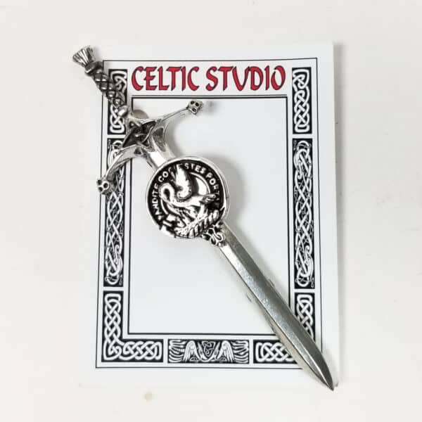 A decorative metal dagger featuring a dragon design is displayed on a card labeled "Celtic Studio," adorned with Celtic knot artwork, evoking the style of the Gibson Clan Crest Pewter Kilt Pin.