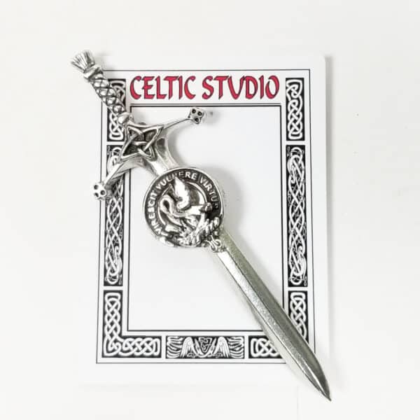 Silver dagger letter opener on a decorative card labeled "Celtic Studio," inspired by the Stewart Clan Crest Pewter Kilt Pin, elegantly blending tradition with functionality.