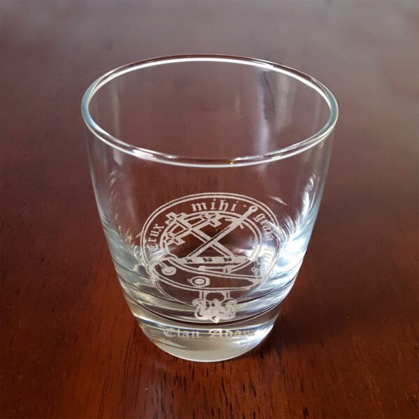 A Clan Crest 10 oz Lowball Rocks Whisky glass sitting on a table.