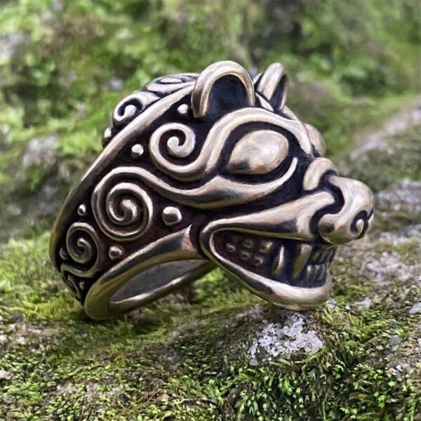 A Norse Bear Ring with a wolf head on top of moss.