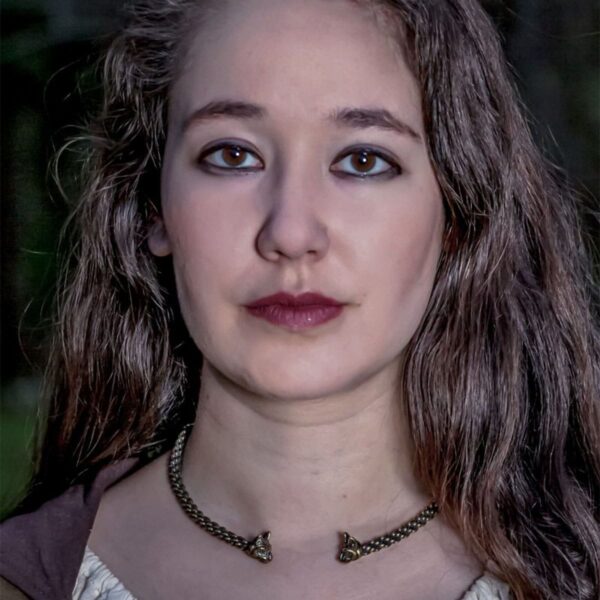 A young woman wearing a Cat Bronze Torc - 16inch Light Braid 6mm in the woods.