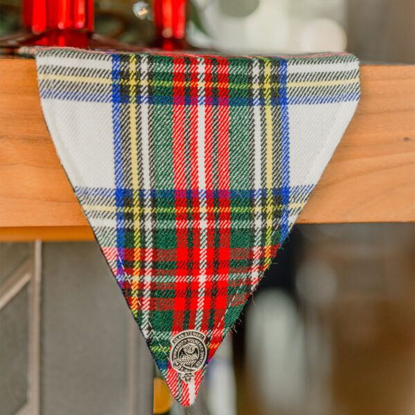 A plaid dog bandana hanging on a Stewart Dress/MacKenzie Tartan Mantel Runner - Homespun Wool Blend.