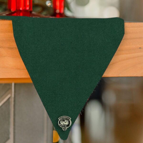 A green Stewart Dress/MacKenzie Tartan Mantel Runner - Homespun Wool Blend hanging on a mantle.