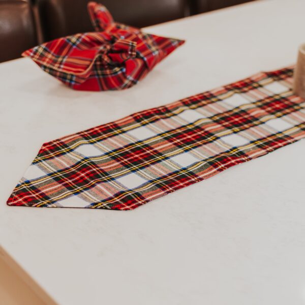 A Stewart Dress/MacKenzie Tartan Mantel Runner - Homespun Wool Blend decorates the table.