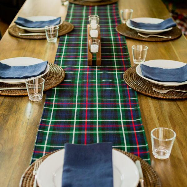 The Black Watch Ancient/Solid Green Reversible Tartan Table Runner - Homespun Wool Blend is set up on a table.