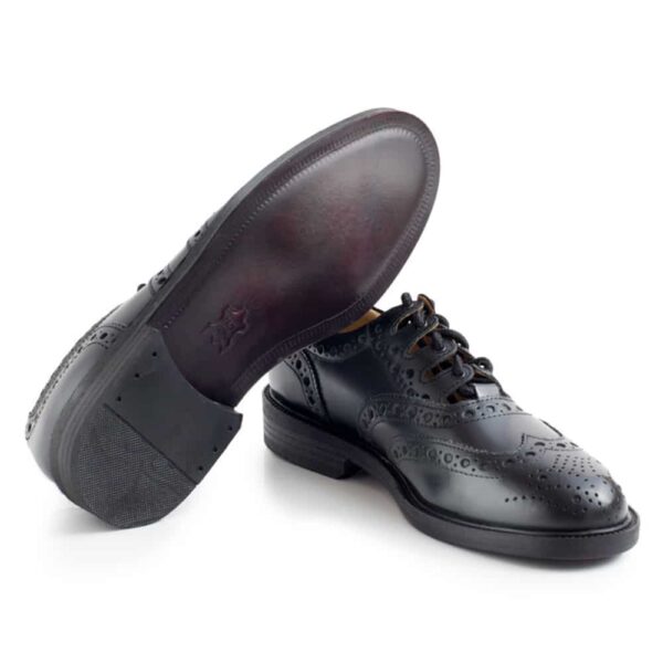 A pair of men's black wingtip ghillie brogues with a leather sole.