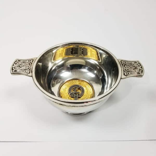 A silver Elliot Clan Crest Quaich with a gold handle.