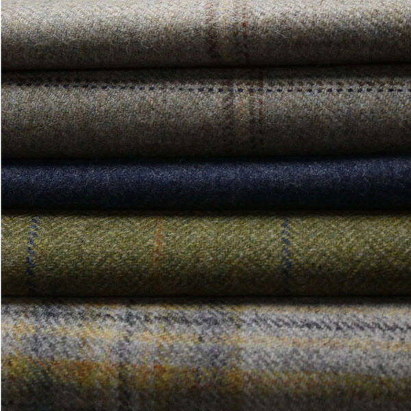 A collection of Twill Tweed Fabric, showcasing soft woolen textiles in a variety of colors and patterns including grey, blue, green, and plaid.