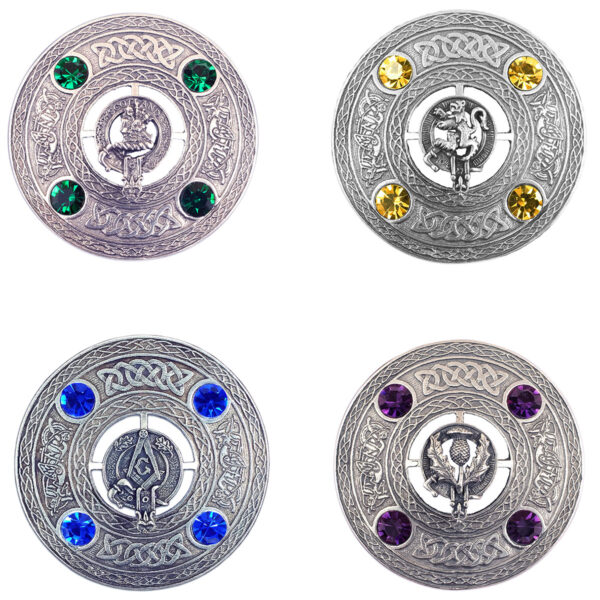 Four Crest and Gem Plaid Brooches, each ornate and round with intricate silver designs and colored gemstones: green, yellow, blue, and purple. Every gem-adorned brooch showcases a unique central crest along with decorative patterns.