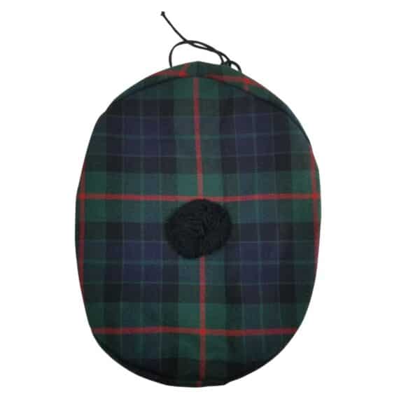 A flat, tartan-patterned cap with green, blue, and red stripes and a small black pom-pom on the top, known as the Gunn Modern Spring Weight Tartan Balmoral.