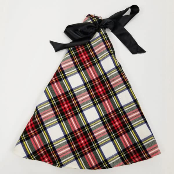 A gift bag made from the Stewart Dress Tartan Tree Skirt's homespun wool blend, featuring a plaid pattern with red, white, and yellow stripes and a black ribbon tie at the top.