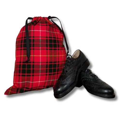 A Santa Bags - Homespun Tartan drawstring bag sits next to a pair of black dress shoes.