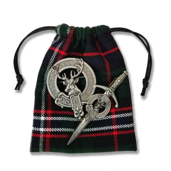 The Keep Sake Tartan Jewelry Bag features two silver pins: one designed as a deer head and the other in the shape of a sword.