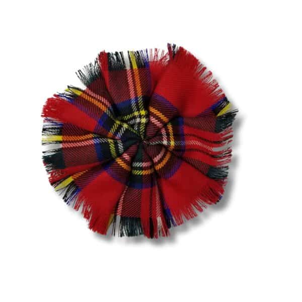 The Stewart Royal Poly/Viscose Tartan Rosette, displaying an array of red, blue, green, and yellow colors, is designed with fringed edges and a gathered center set against a white background.