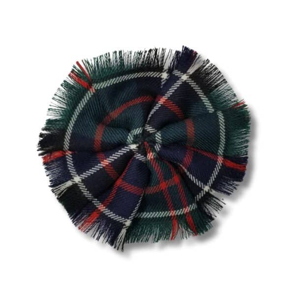 Introducing the Stewart Royal Poly/Viscose Tartan Rosette: a round fabric badge with fringe edges, featuring the iconic Stewart Royal Tartan in vibrant green, blue, red, and white hues. Crafted from a durable Poly/Viscose blend for lasting quality.