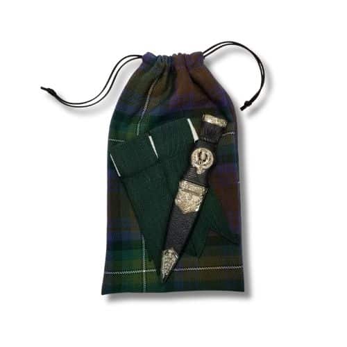 A Scottish sgian dubh encased in a decorative sheath is elegantly displayed on a homespun tartan cloth, perfectly complemented by a matching Santa Bag from the Homespun Tartan collection.