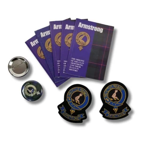 A collection of five brochures titled "Armstrong Clan" in purple, describing the history of the Armstrong family, along with a silver round object, a blue round badge, and two black crest patches featuring the text "Invictus Maneo.