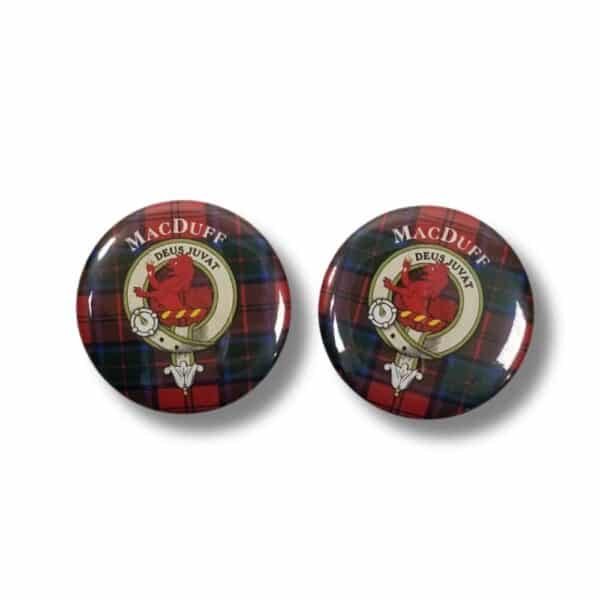 Two round pins featuring a red plaid background showcase a crest with a red lion, embellished with the text "Armstrong" and "Deus Juvat." This design subtly honors the rich heritage of this Scottish clan, adding depth and tradition.