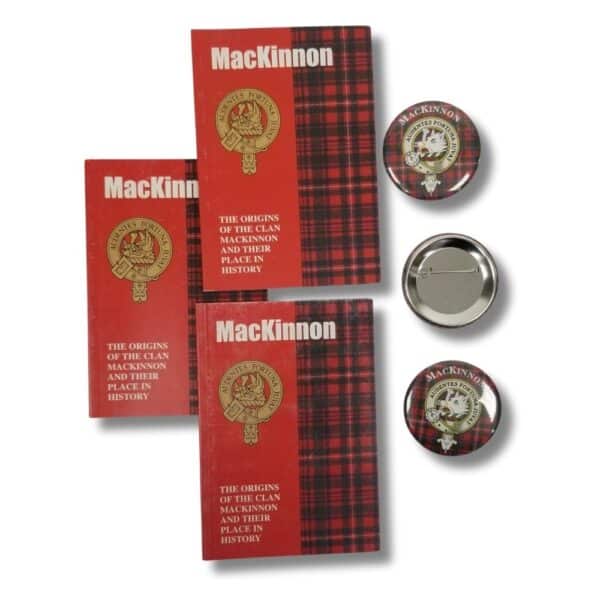 Two red plaid books titled "The Origins of Clan MacKinnon and Their Place in History," adorned with a crest design, sit alongside three round buttons featuring the same Armstrong Clan emblem.