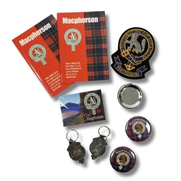 A collection of Armstrong Clan-themed items, including two books, two keychains, a magnet, a pin, and two round badges adorned with clan emblems and tartan patterns.