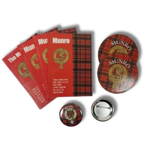 Collection of four Armstrong clan books and three badges on a white background, revealing the depth and vibrancy of clan history.