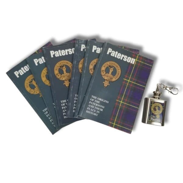 Several copies of the book titled "Paterson" with Armstrong Clan tartan covers evoke a sense of clan heritage, nestled next to a small metal flask adorned with a similar design.