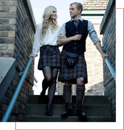 A man and woman in kilts standing on steps, showcasing the perfect kilt attire.