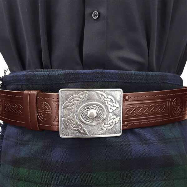 A belt with a silver buckle on a plaid kilt.