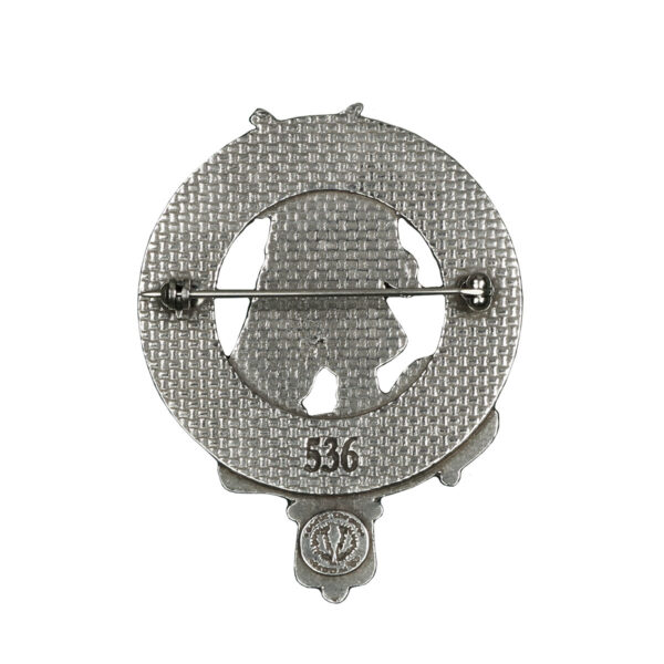 A Scottish Scottish Piper Cap Badge/Brooch with an image of a bear in a circle.