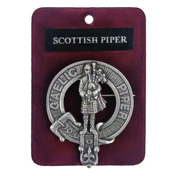 A Scottish Piper Cap Badge/Brooch packaged with a cap.
