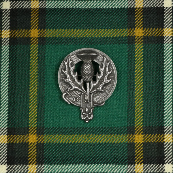 A Scottish Thistle Cap Badge/Brooch on a tartan.