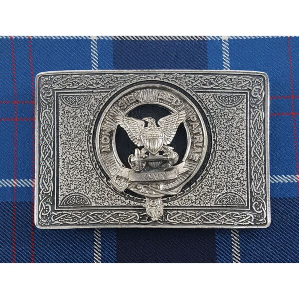 A silver U.S. Navy Pewter Kilt Belt Buckle with an eagle and a US navy brooch.