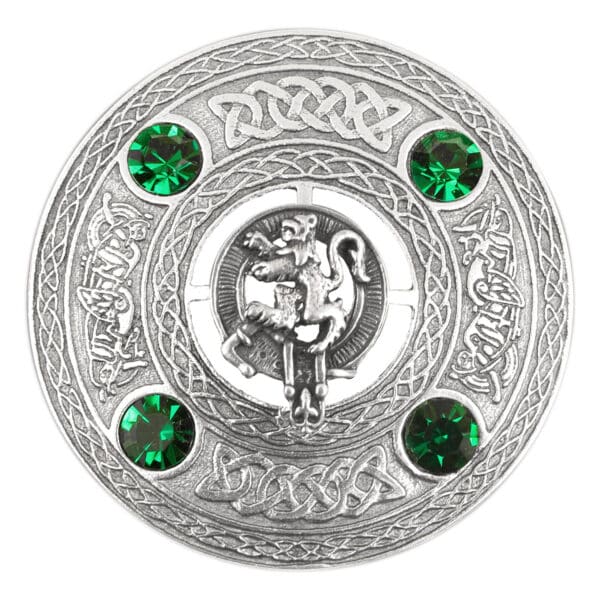 A Rampant Lion Plaid Brooch adorns a plaid brooch, showcasing emerald stones on a silver plate.