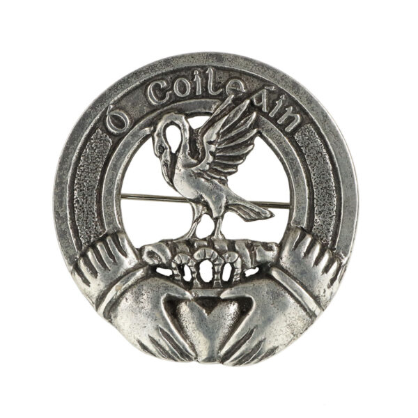 An Irish Family Crest Cap Badge/Brooch featuring a silver brooch with an image of an eagle and a heart.