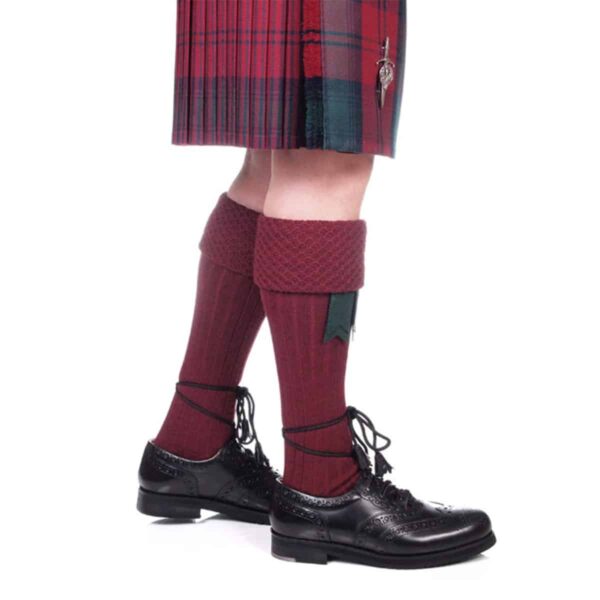 A piper donning a Piper Kilt Hose (Special Order) and black shoes.