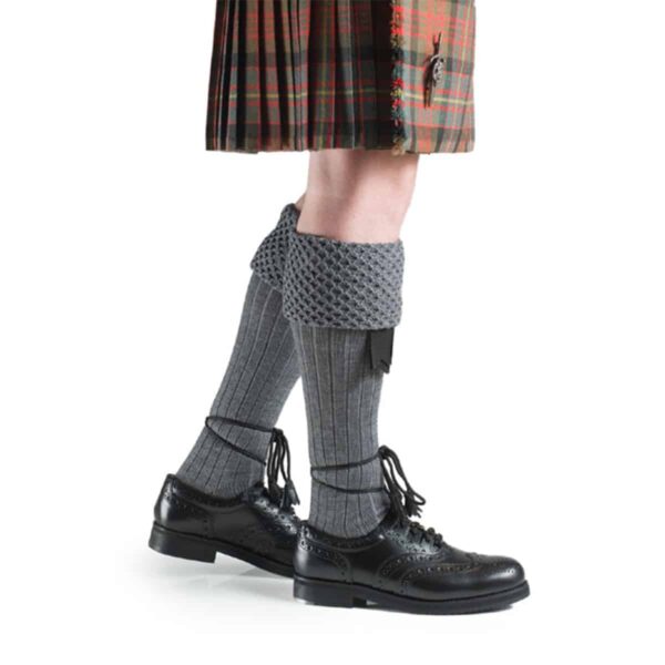 A Piper Kilt Hose wearing a kilt and black hose (Special Order).