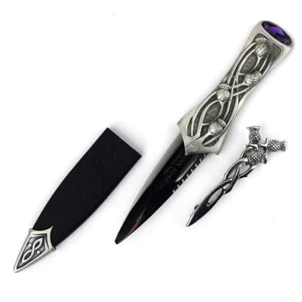 A black and silver knife with an amethyst handle, featuring a Pewter Scottish Thistle Knot Sgian Dubh design inspired by the Pewter Sgian Dubh tradition.