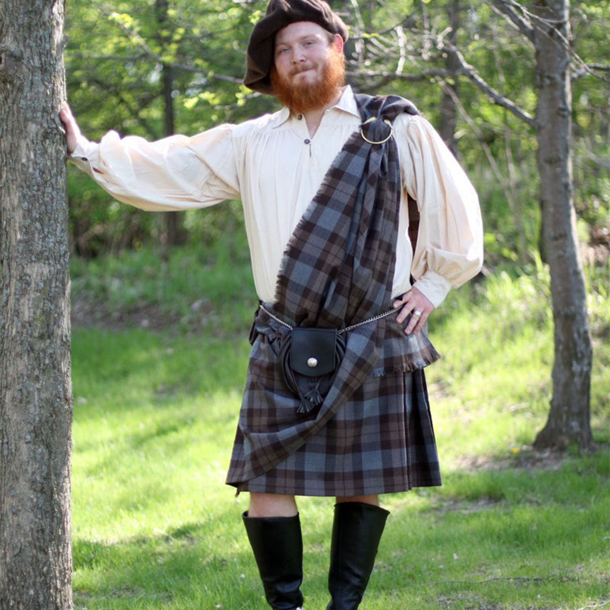 An ancient Irish Tartan Ancient Kilt - Homespun Wool Blend-clad man leaning against a tree, wearing an Irish tartan.