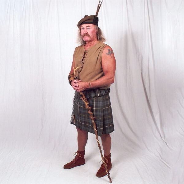 A man dressed in a Medium Weight 13oz Old & Rare Premium Wool Phillabeg, holding a spear.