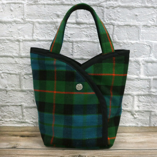 A Bag - Poly/Viscose Wool-Free tartan tote bag in green and orange, resting on a wooden floor.