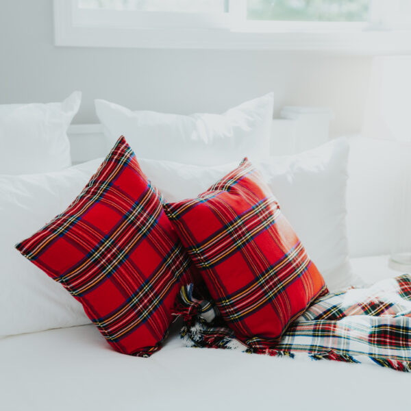 A bed with Homespun Tartan pillows and a Homespun Tartan Blanket/Throw.