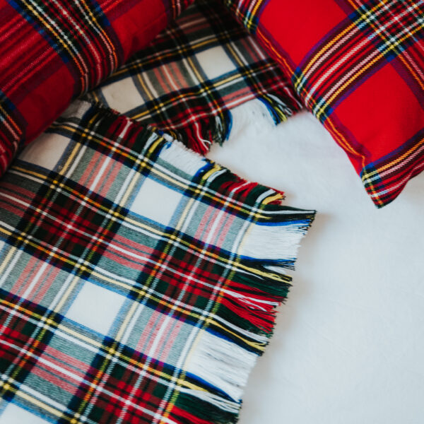 A red and white Homespun Tartan Blanket/Throw on a bed.
