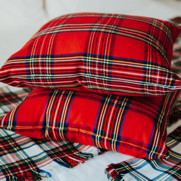 Two plaid pillows on top of a bed adorned with Homespun Tartan Blanket/Throw.