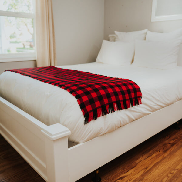 A white bed with a Homespun Tartan Blanket/Throw.