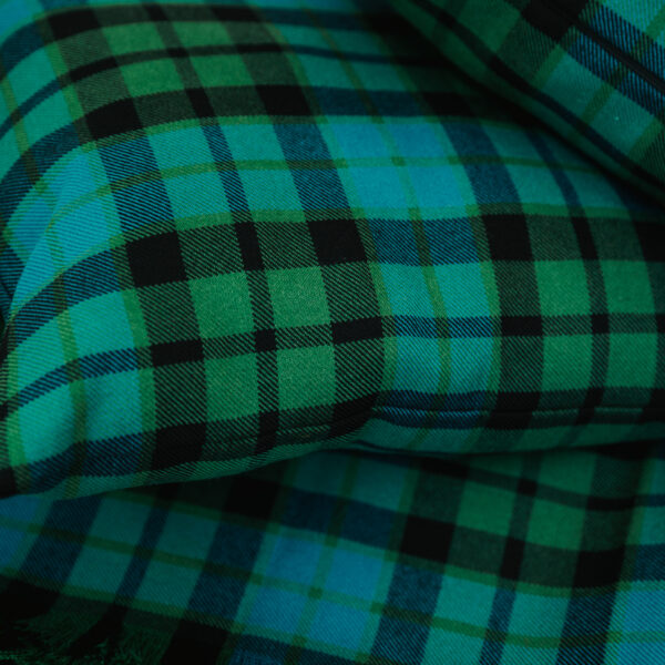 A close up of a green and black Homespun Tartan blanket/throw.