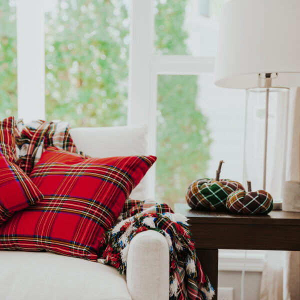 Homespun tartan blankets/throws on a couch in a living room.